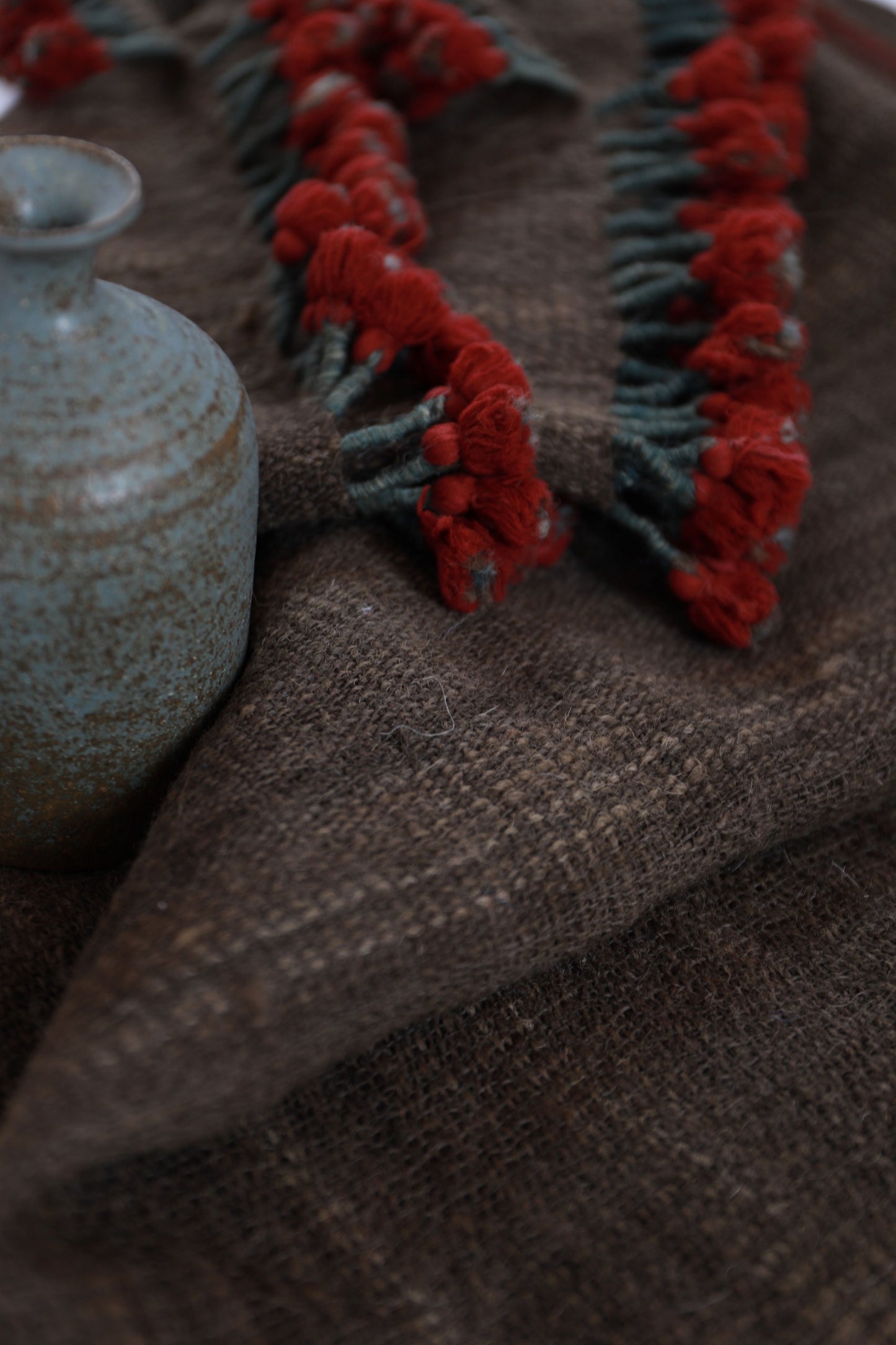 Close-up of a textured surface with red floral patterns and a blue cylindrical object.