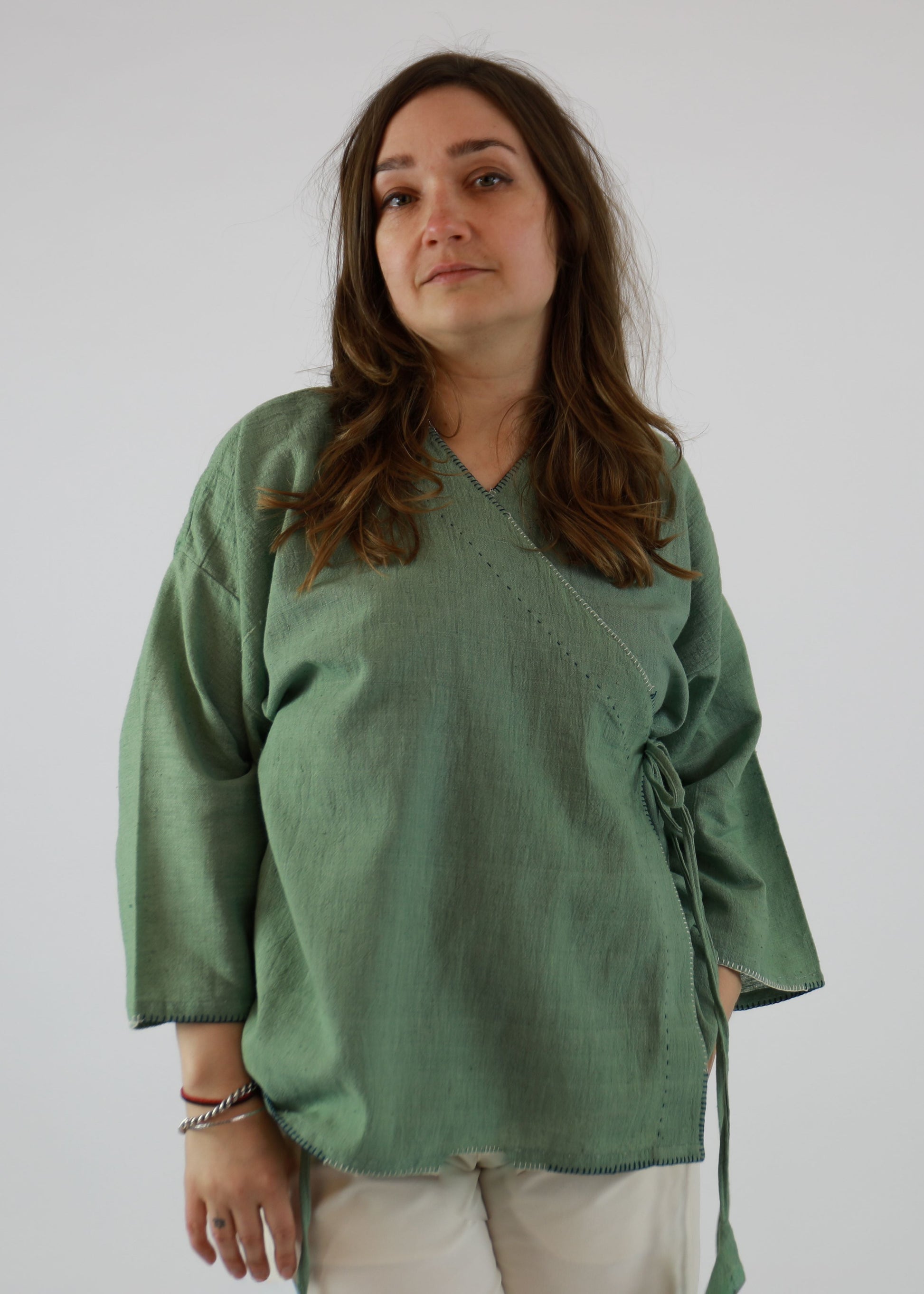 Woman wearing a green blouse with a plain background