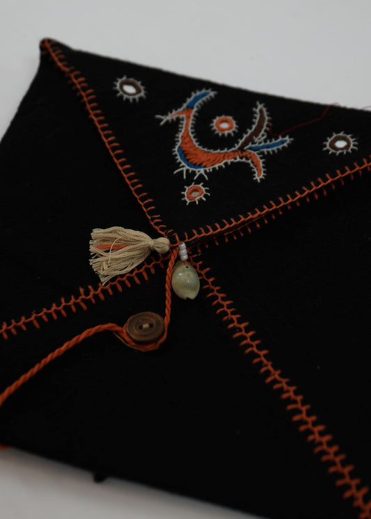 Black fabric with orange embroidery on a white background